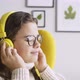 Woman Puts on Headphones and Listening Music - VideoHive Item for Sale