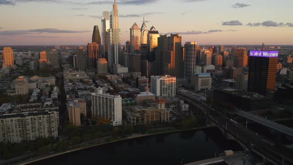 Aerial drone reveal of the downtown Philadelphia skyline featuring tall, glass skyscrapers at sunset