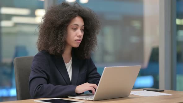 African Businesswoman Showing Thumbs Down While Using Laptop