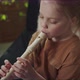 Girl Playing the Flute Sitting Next to Her Mother on the Couch - VideoHive Item for Sale