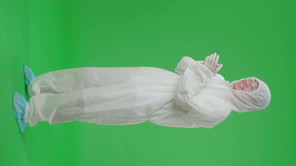 Side View Of Full Body Asian Man Wear Uniform Ppe And Clapping His Hands In The Green Screen Studio