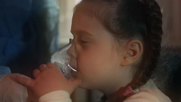 Beautiful Little Girl Makes Inhalation Using a Compressor Inhaler at Hospital