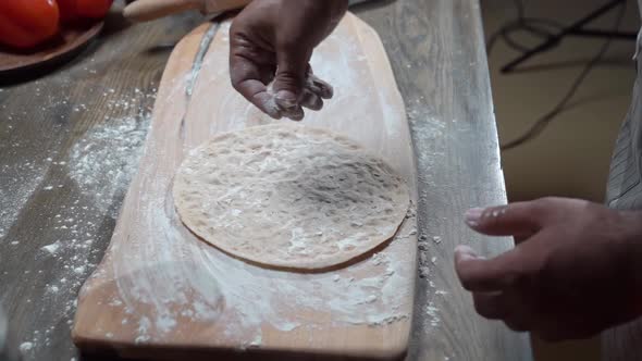 Men's Hands Sprinkle Flatbread with Flour for the Video About Food