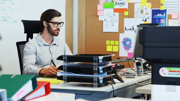 Male graphic designer working on graphic tablet at desk