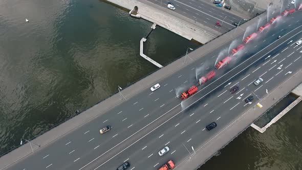 Several Special Watering Machines Lined Up in a Row Are Pouring Water on the Bridge of One of the