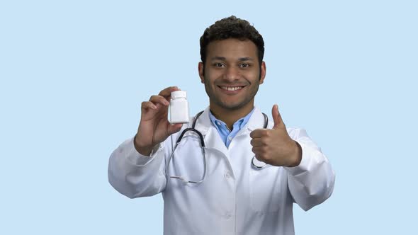 Happy Young Doctor Holding Pills and Showing Thumb Up