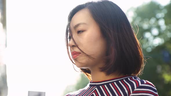 pensive asian woman in the city: sad young woman