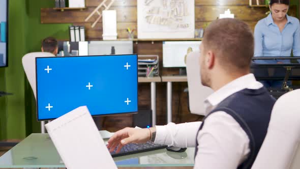 Young Architect Looking at Computer with Blue Screen