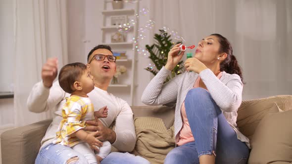 Happy Family with Baby and Soap Bubbles at Home