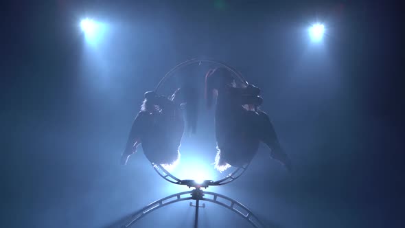 Rotate in the Air Two Gymnasts. Black Smoke Background. Silhouette