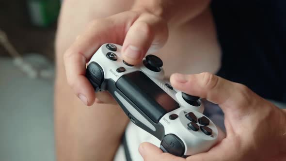 Closeup of the Hands of a Young Man Playing Video Games on a Game Console