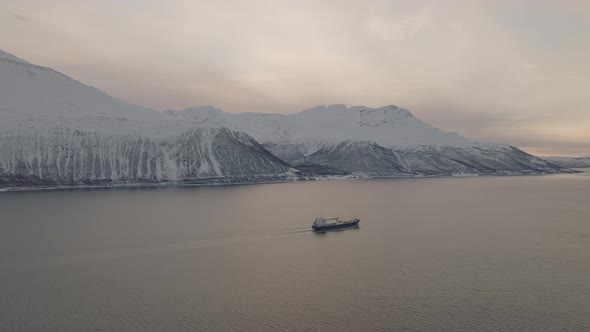 Freighter Shipping Commercial Cargo In Snowy Fjord Landscape, Aerial