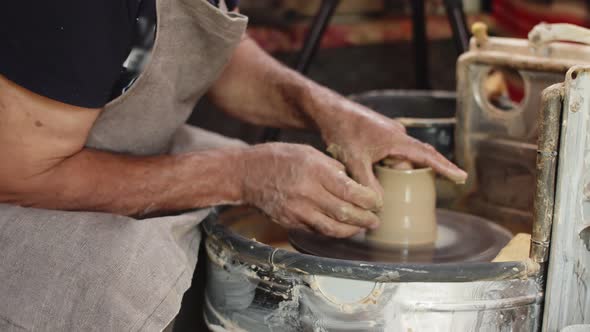 Elderly Male Potter Uses Potter's Wheel and Attaches Thin Walls to Pottery