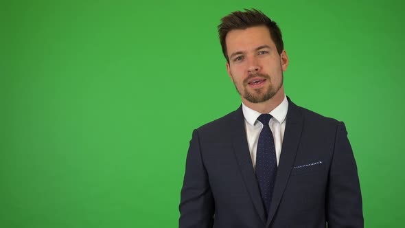 A Young Handsome Businessman Talks To the Camera with a Mild Smile - Green Screen Studio