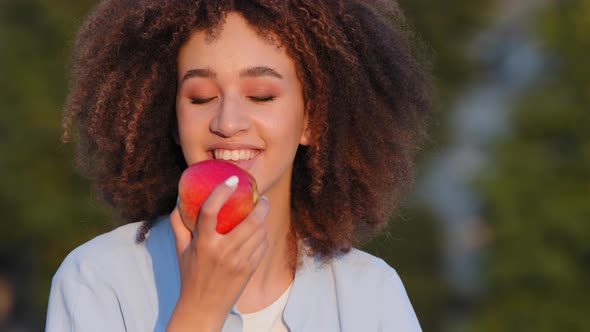 Beautiful Young Happy Black African American Girl with Pleasure Eat Delicious Red Apple Healthy