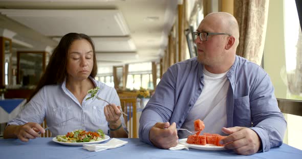 Stylish Couple Eats Salad and Watermelon Sitting By Window