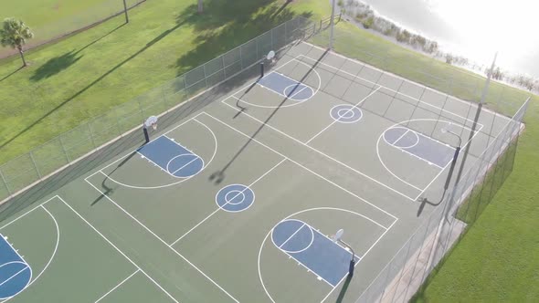 Super smooth drone flight turning over 3 perfectly painted public blue basketball courts