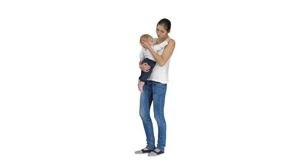 Young Mother Trying to Calm Down Infant Son on White Background