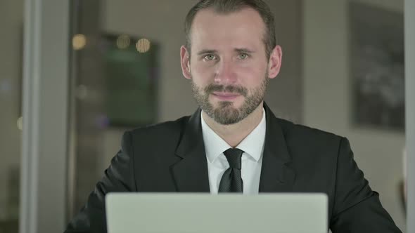Close Up of Businessman Showing Thumbs Up in Office at Night