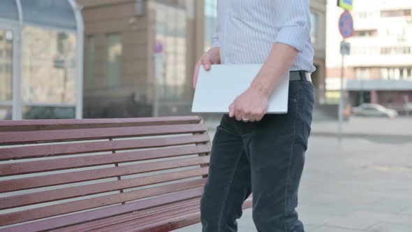 Old Man Coming Sitting on Bench and Opening Laptop