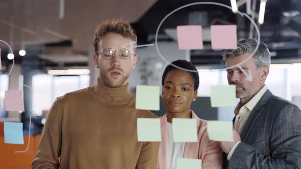 Young Business Staff Brainstorming New Project Solving Strategy on Glass Board