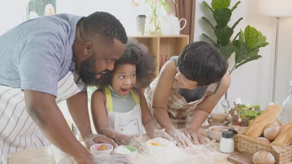 African American family with daughter thresh flour with excited for cooking with father and mother.