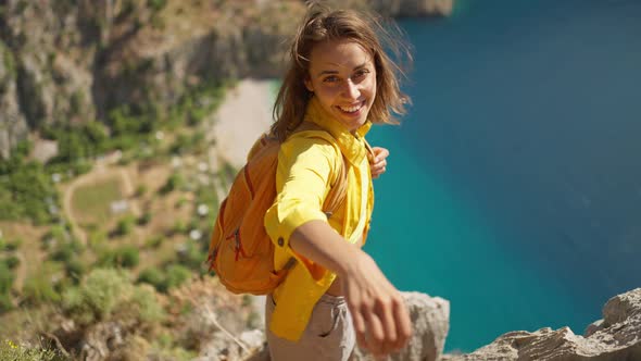 POV First Person View Happy Beautiful Young Woman Tourist in Yellow Shirt Stands on Cliff Edge Over