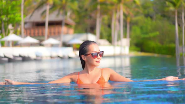 Young asian woman enjoy around outdoor swimming pool for leisure