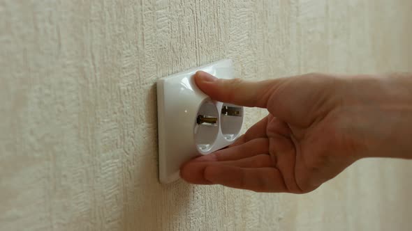 A close-up of a loose protruding socket is being repaired by a home craftsman. An electrician with a