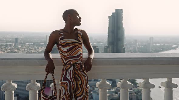 Fashion Model Leaning Against Balustrade Over City