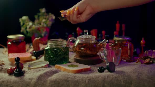 Closeup of Small Jar with Jam and Piece of Bread on Table