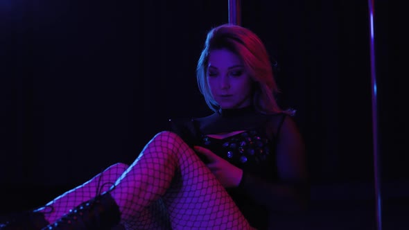 Portrait of Sitting Woman Pole Dancer in Club