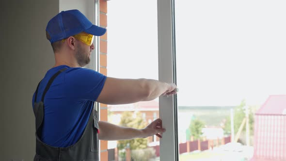 Man Closes Window for Checking Satisfactory State of Handle