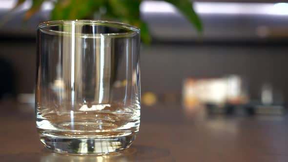 Fresh Cherry or Grape Juice Pouring in a Glass on Wooden Table