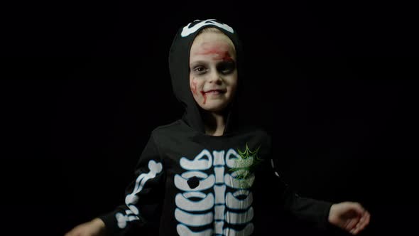 Halloween Angry Girl with Blood Makeup on Face. Kid Dressed As Scary Skeleton, Dancing, Making Faces