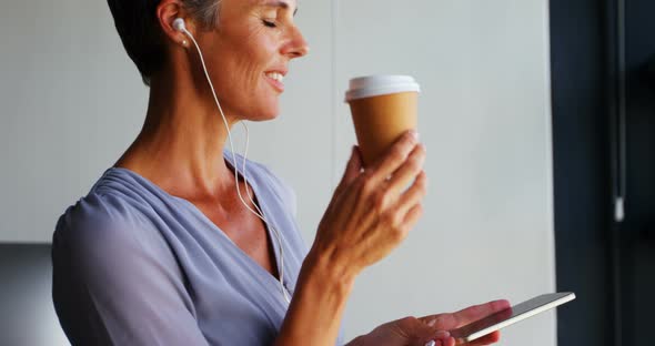 Businesswoman Having Coffee While Listening Music on Mobile Phone 4k