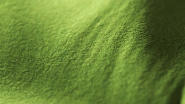 Highly detailed green cloth fabric fluttering on the wind. Surface fiber pattern