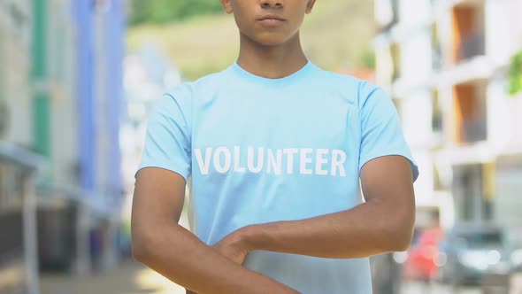 Responsible volunteer folding hands, serious duties in charitable organization