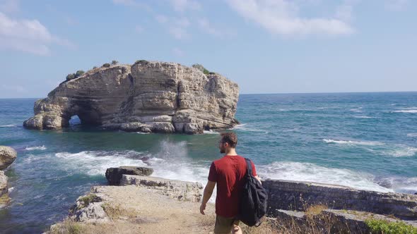 Adventurous young man walking on sea cliffs.