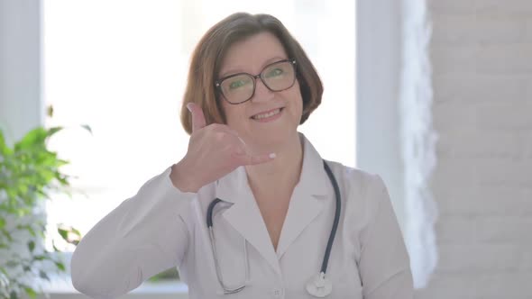 Senior Female Doctor Showing Call Me Sign