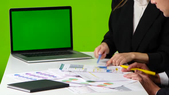 Work Desk in the Office, Man and Woman Draw a Graph, Open Notebook with Green Screen