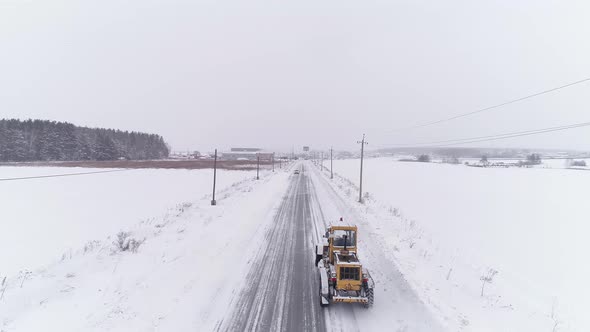 Aerial view of Snowblower Grader is driving on a winter snowy road 09