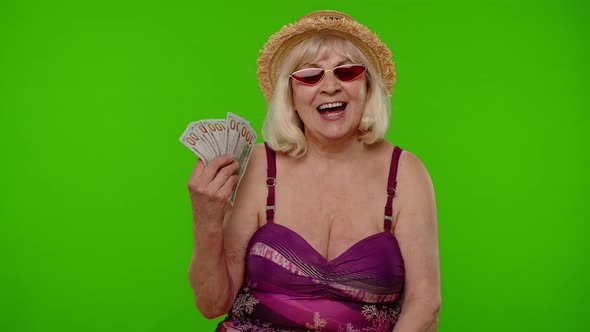 Rich Senior Woman Tourist with Cash Fan Enjoying Financial Independence Waving Currency Dollar Bills