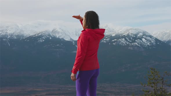 Adventurous Girl Hiking in the Mountains During a Sunny Winter Sunset