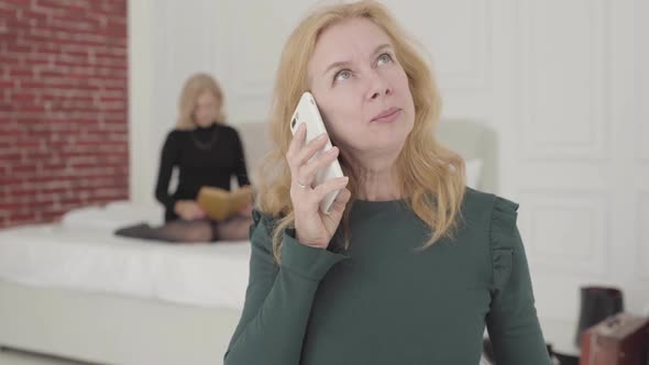 Portrait of an Attractive Caucasian Mature Woman Talking By the Phone at Home