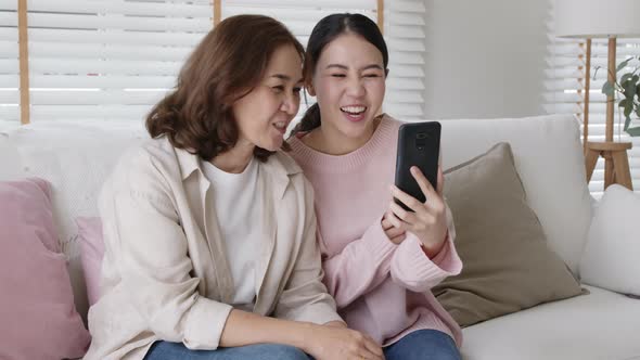 Happy playful fun asian family selfie phone parent home fun smile.