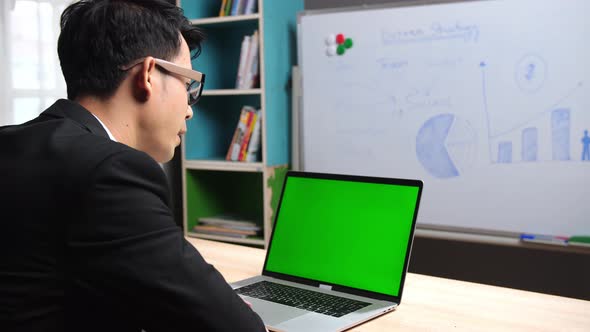 Back Of Businessman Talking With Green Screen Laptop 