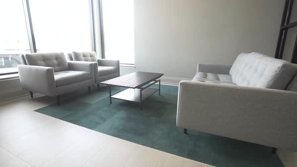 Modern grey couches in a European condo with an elegant chandelier.