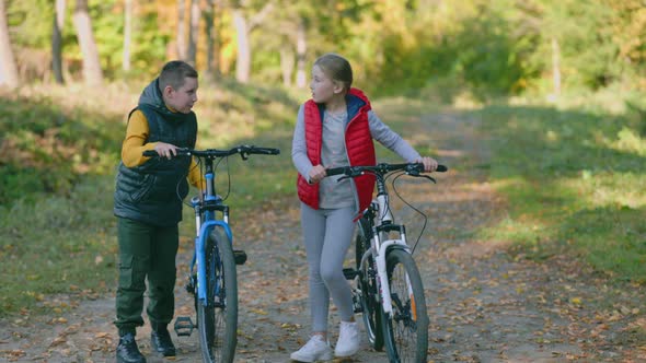 Children Walk in Nature with Bicycles