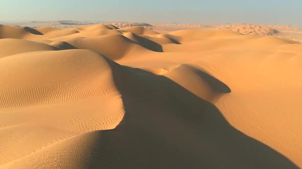 Aerial Shot of Sand Dunes in Desert. Flying Over Endless Yellow Sand Dunes at Sunset